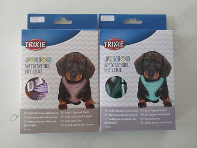 Two TRIXIE Junior soft harnesses with leashes on packaging against a white background