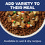 Dog food with added vegetables in a bowl on a blue background with text about variety in meals.