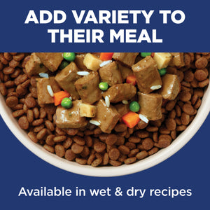 Dog food with added vegetables in a bowl on a blue background with text about variety in meals.