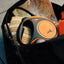 Orange and black retractable dog leash with a map and snacks in the background