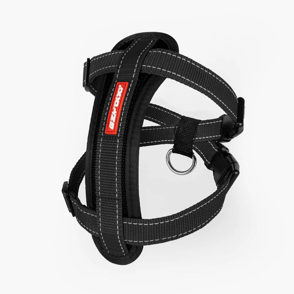 Black dog harness with a red brand label on a white background