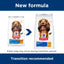 Two packages of Hills Science Diet dog food with a blue arrow and text indicating a new formula transition.