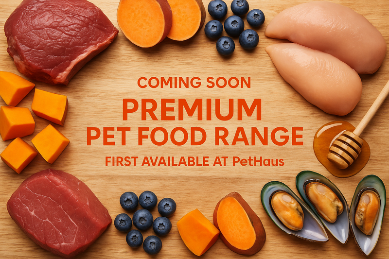lets create an image for our upcoming product range of premium quality pet foods, i want the back ground to be light grain wood like a cutting board, with a range of differnet key ingredients setout around the border and placed across the cutting board background with healthy fresh cuts of meat, pumpkin, kumara, blueberries and green lipped mussels, manuka honey. the text in the middle should sate the up and coming product to be first sold via PetHaus. all tect to be in  - Text (Bold Orange): #FF5A00
