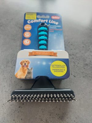 Pet grooming brush with packaging on a concrete surface