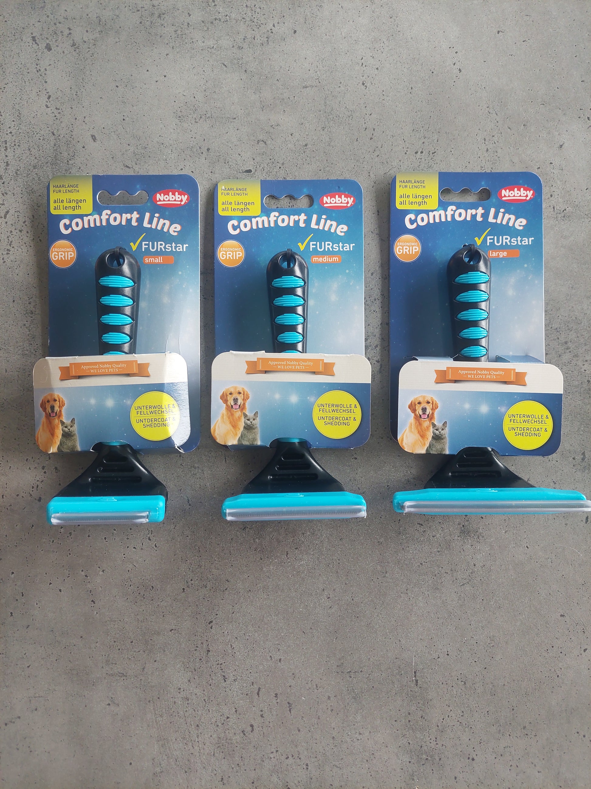 Three packages of Rubis comfort line dog toys on a concrete floor.