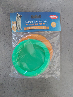 Green silicone lid and packaging on a gray surface