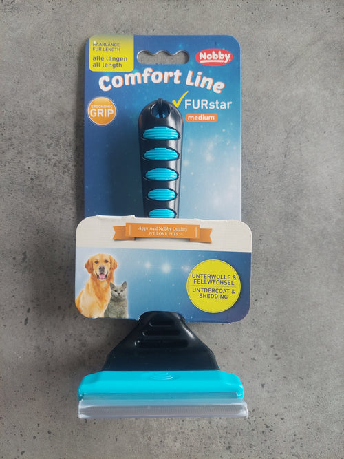 Pet grooming brush with Nobby packaging on a gray surface